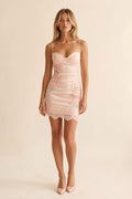 Front view of model wearing pink floral embroidered satin corset mini dress