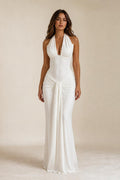 Front view of woman wearing white draped halter neck maxi dress