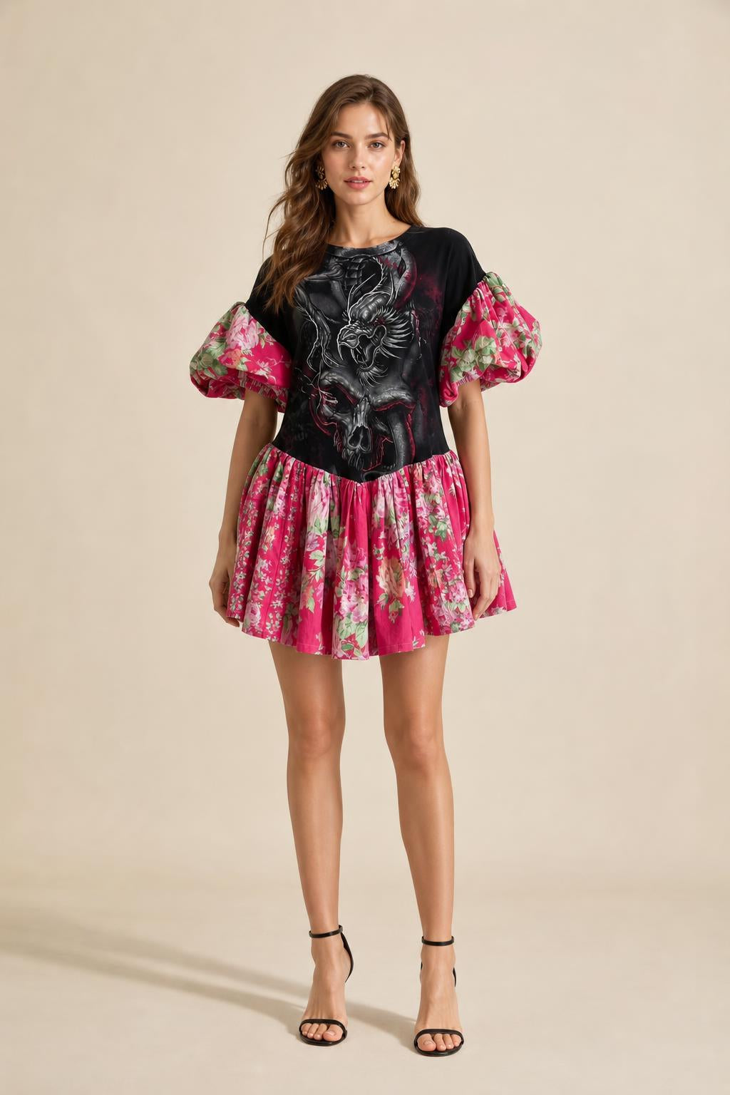 Front view of model wearing black graphic print puff sleeve drop waist mini dress