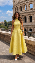 Front view of butter yellow halter neck jacquard midi dress with full skirt