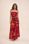 Model wearing red floral strapless crop top and maxi skirt set front view