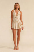 Front view of model wearing champagne halter sequin floral romper