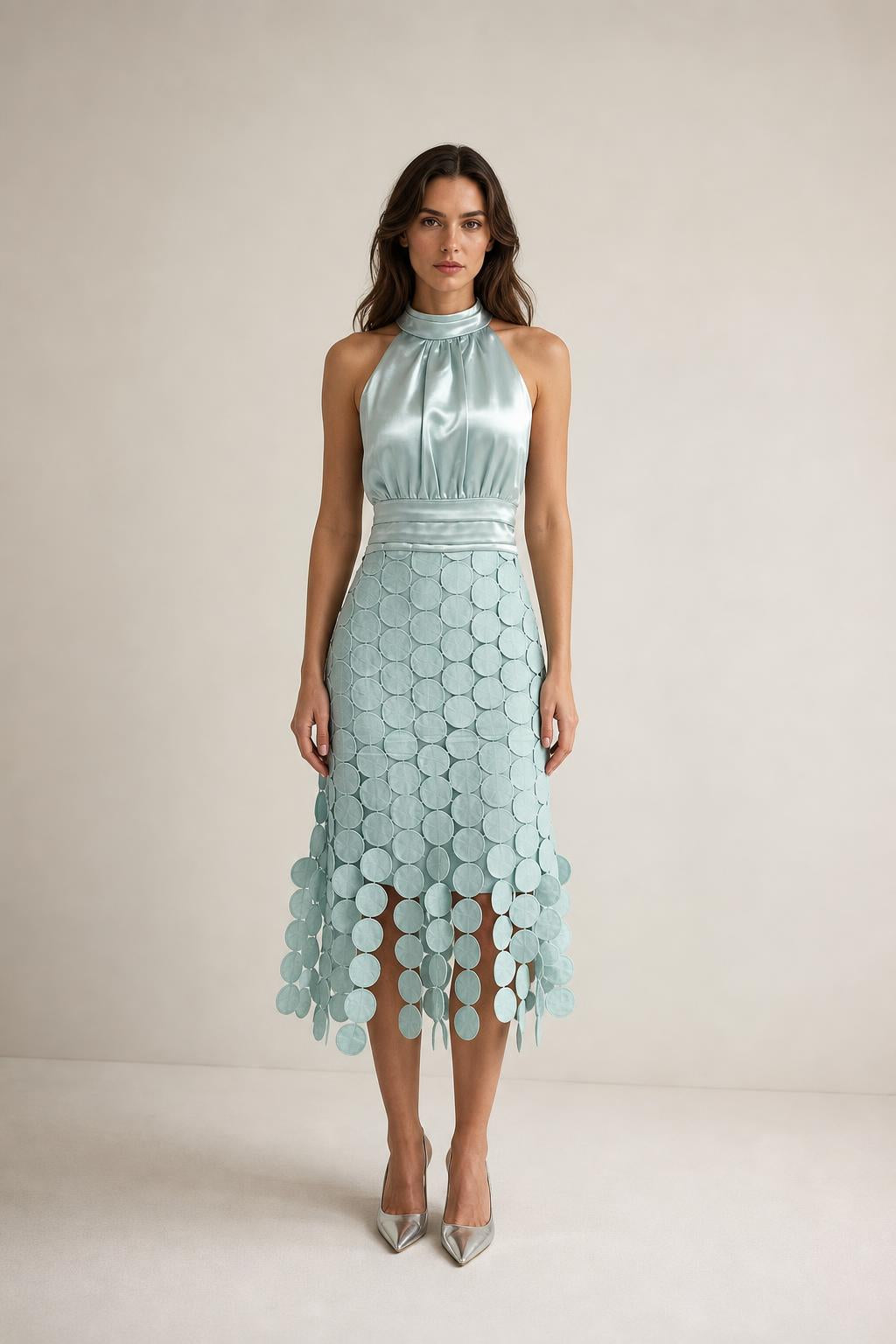 Front view of sage green satin halter neck midi dress with circle fringe hem