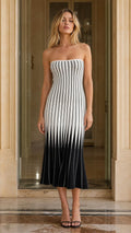 Front view of woman wearing Black and White striped strapless midi dress