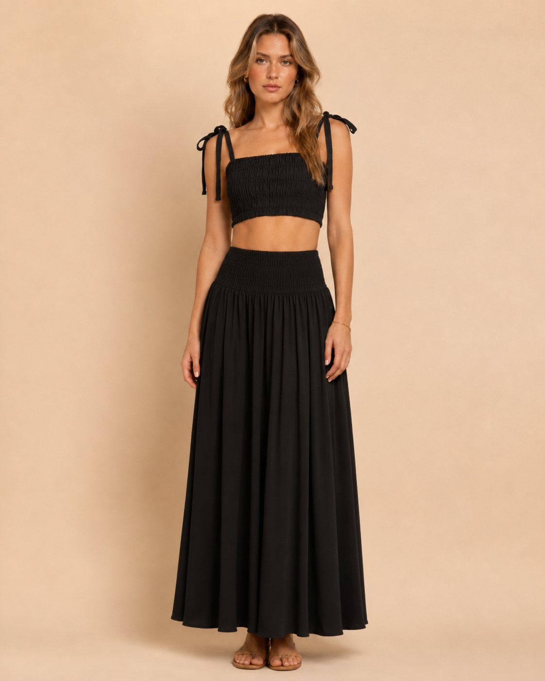 Front view of black smocked tie-shoulder crop top and matching maxi skirt set