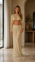 Front view of champagne sequin crop top and maxi skirt two-piece evening set