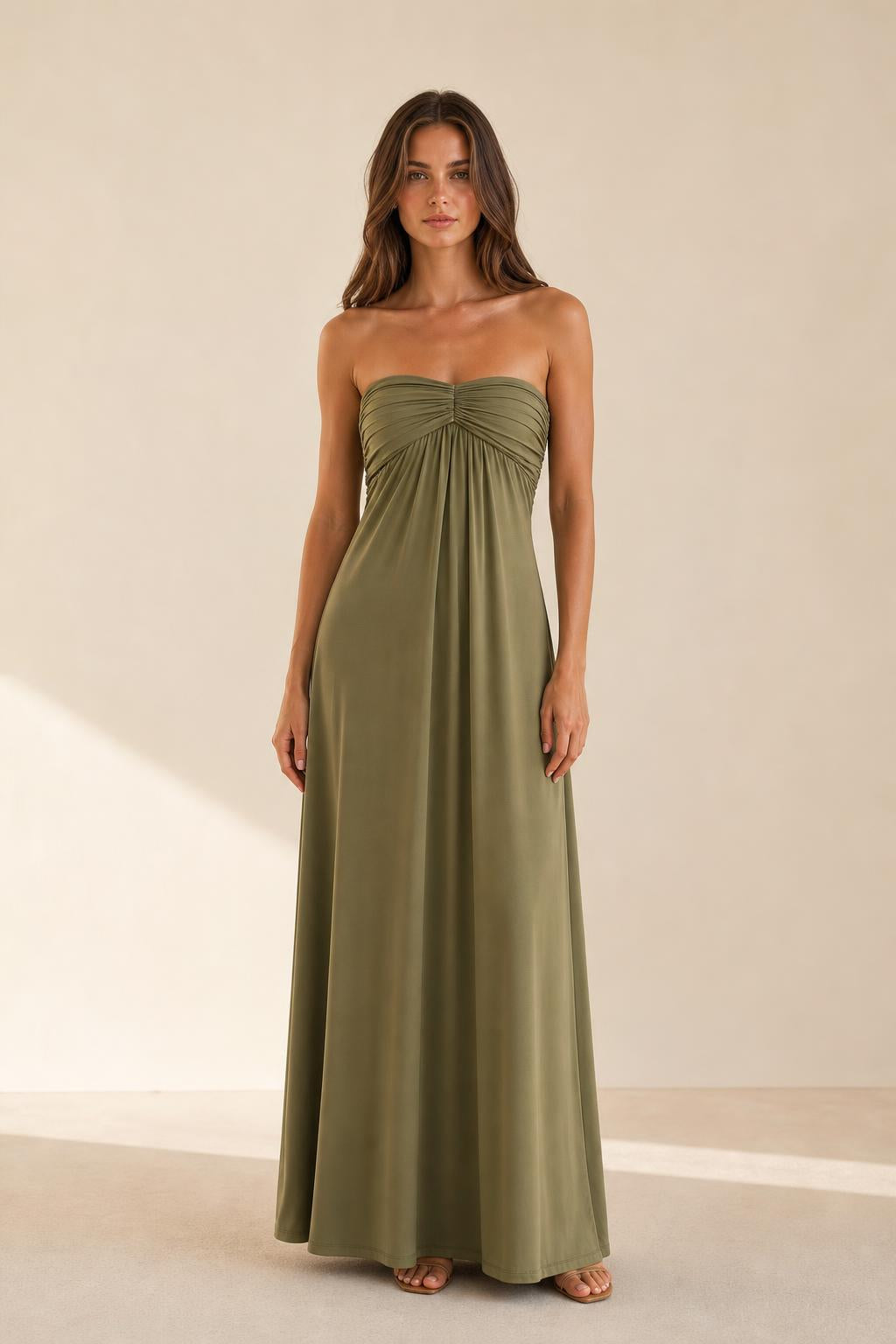 Woman wearing olive green strapless ruched maxi dress front view
