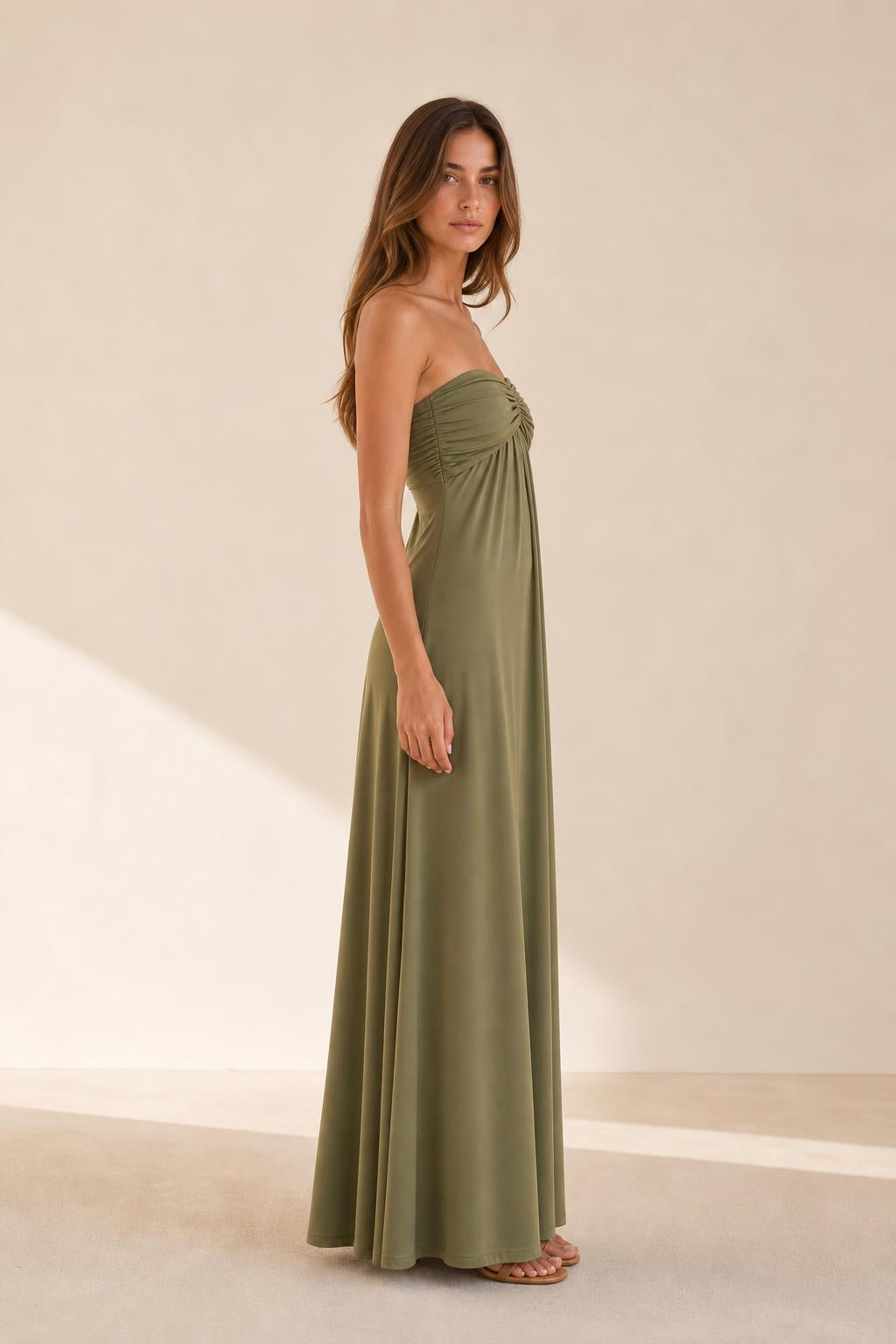 Woman wearing olive green strapless dress side view