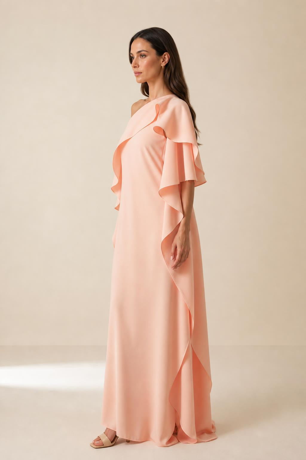 Side profile view of peach one-shoulder ruffle maxi dress