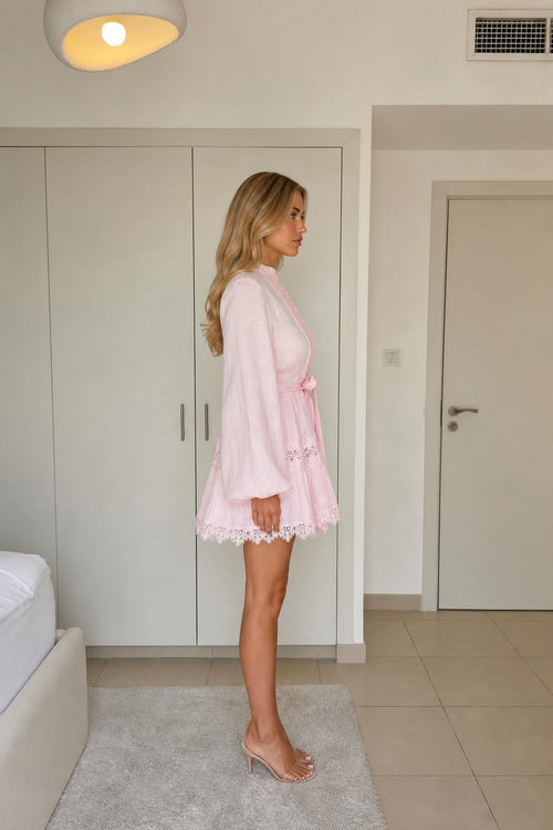 Side profile of model in pink mini dress