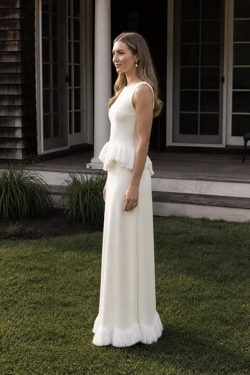 Side profile view of white fringed peplum maxi dress