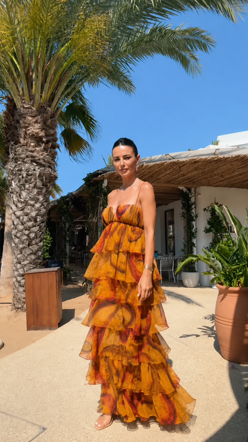 Angled front view of strapless tiered ruffle maxi dress in amber abstract print