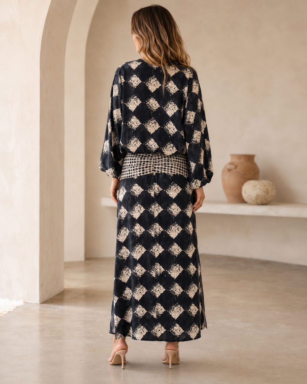 Back view of black printed maxi dress with long balloon sleeves and smocked waist