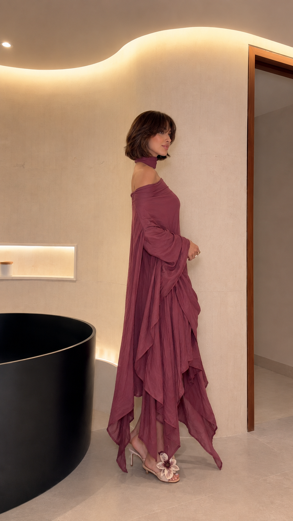 Side view of mauve flowing off-shoulder maxi dress with long sleeves and layered asymmetric hem