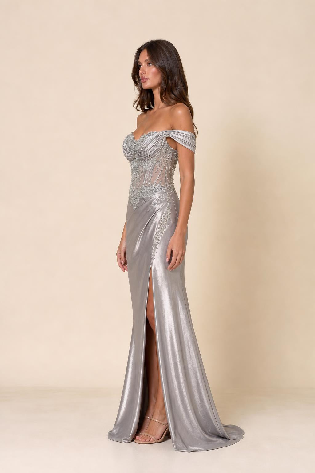 Side profile view of woman in silver evening gown with high slit
