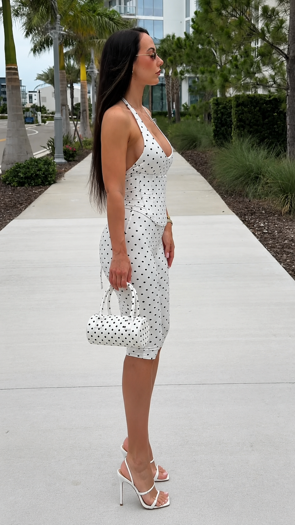 Side view of white polka dot halter knee-length jumpsuit