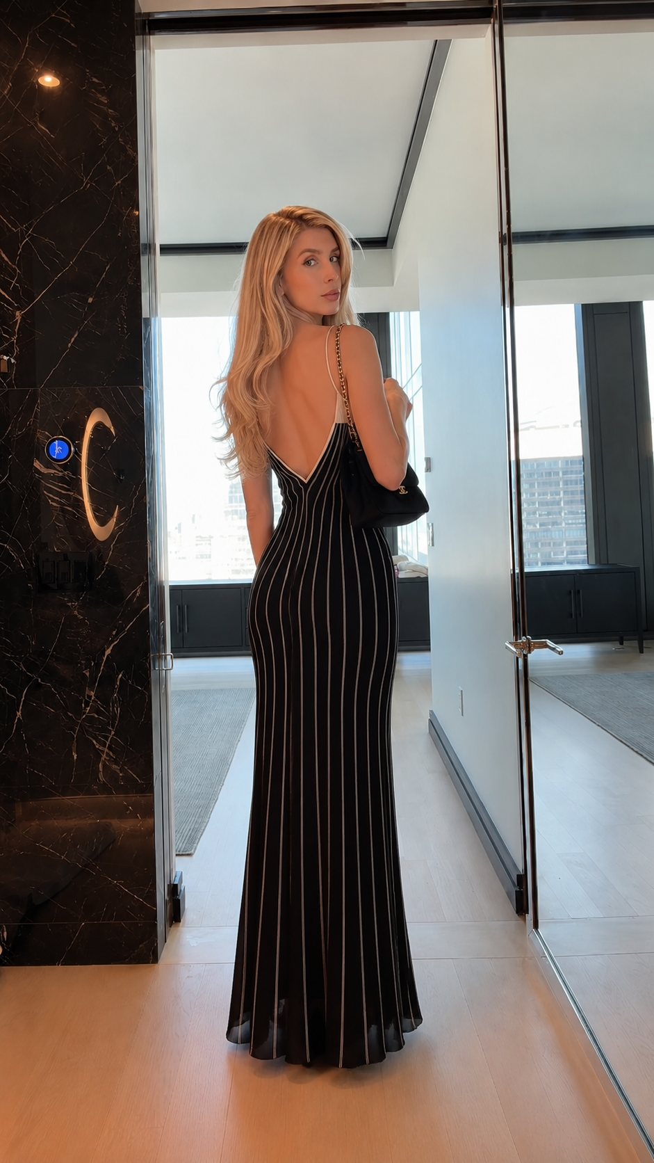 Back view of black striped low-back mermaid maxi dress