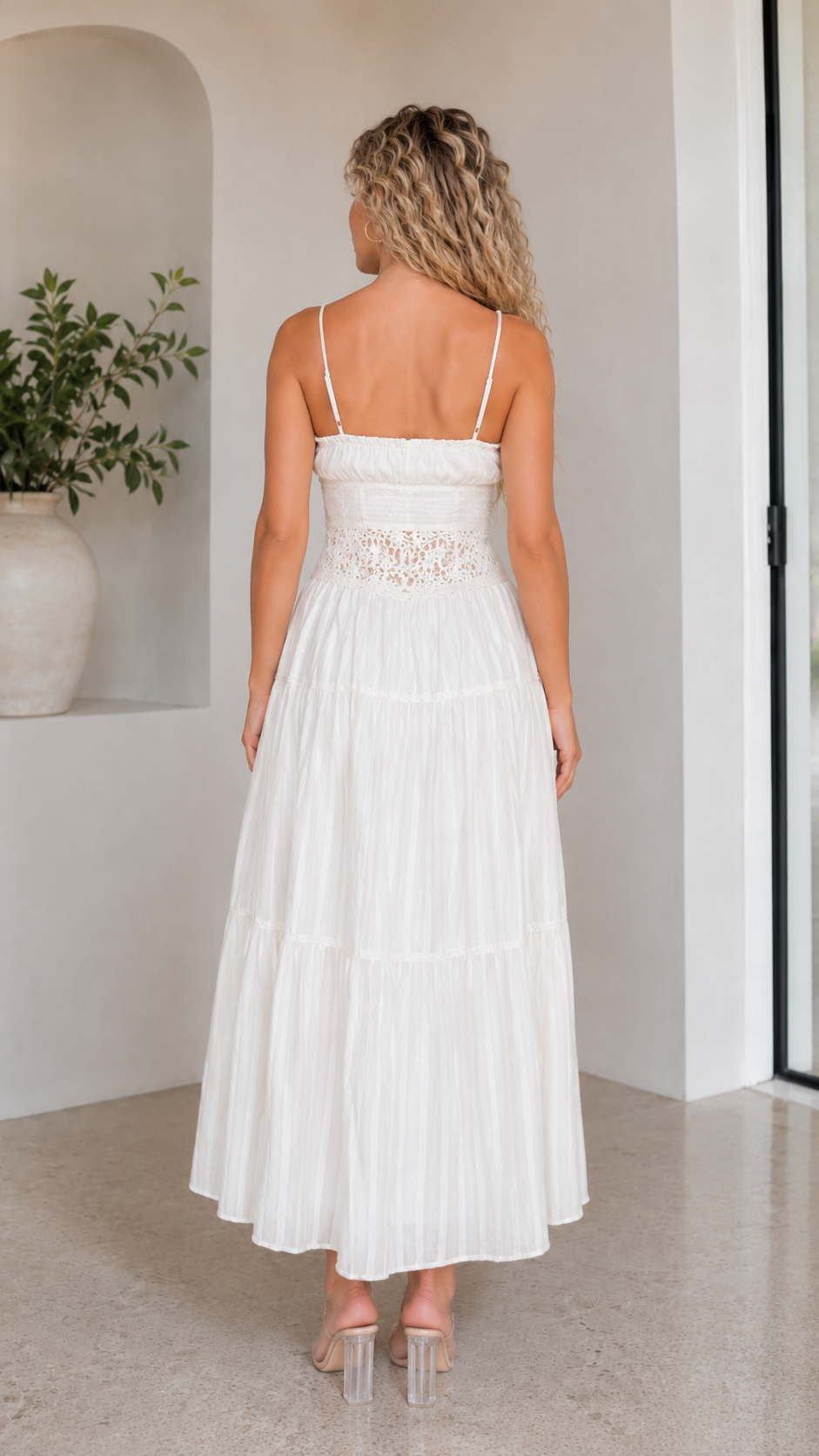 Back view of white sleeveless maxi dress with straight neckline and lace-look waist