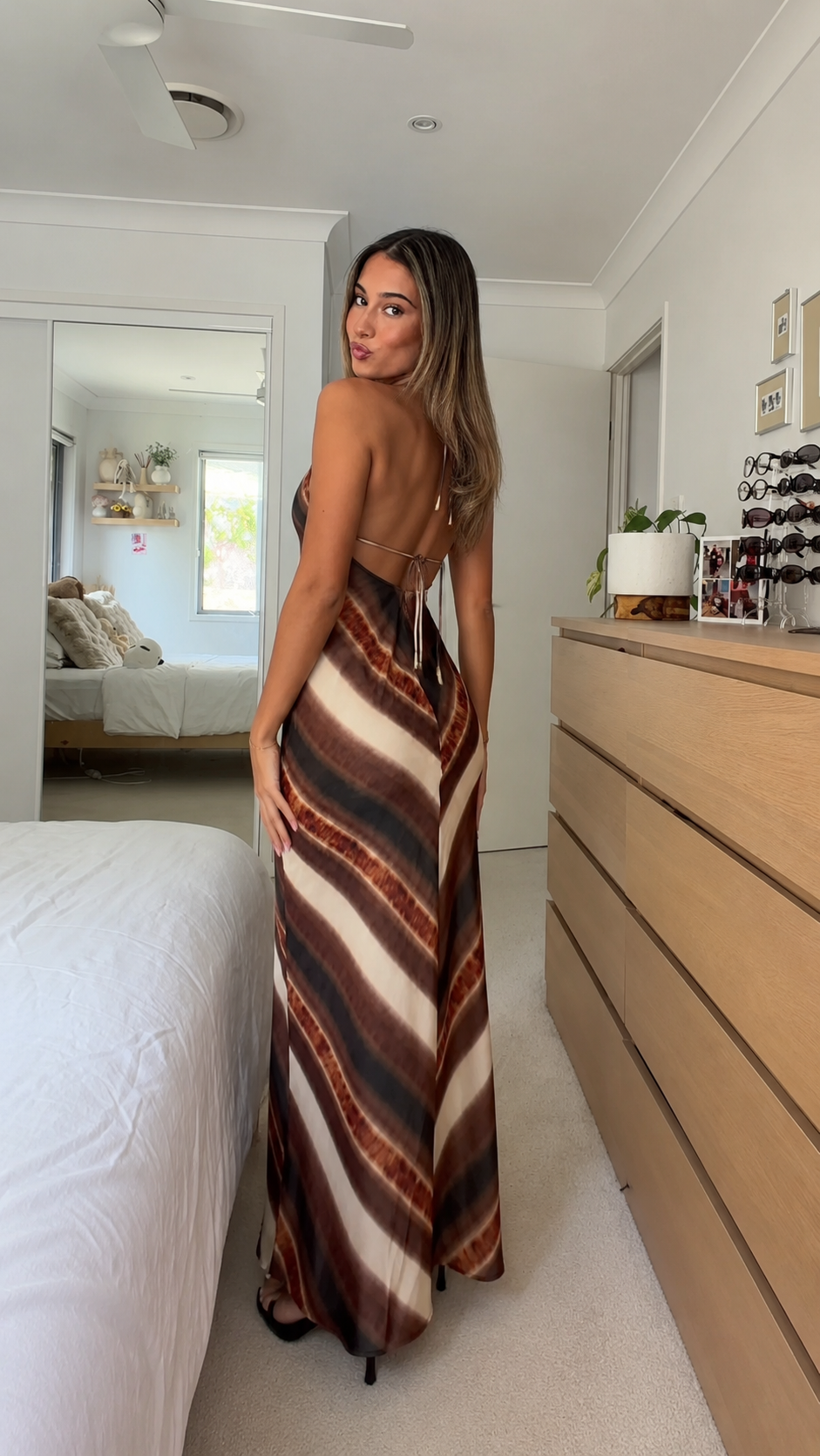 Back view of mocha striped maxi dress showing open back and slim straps