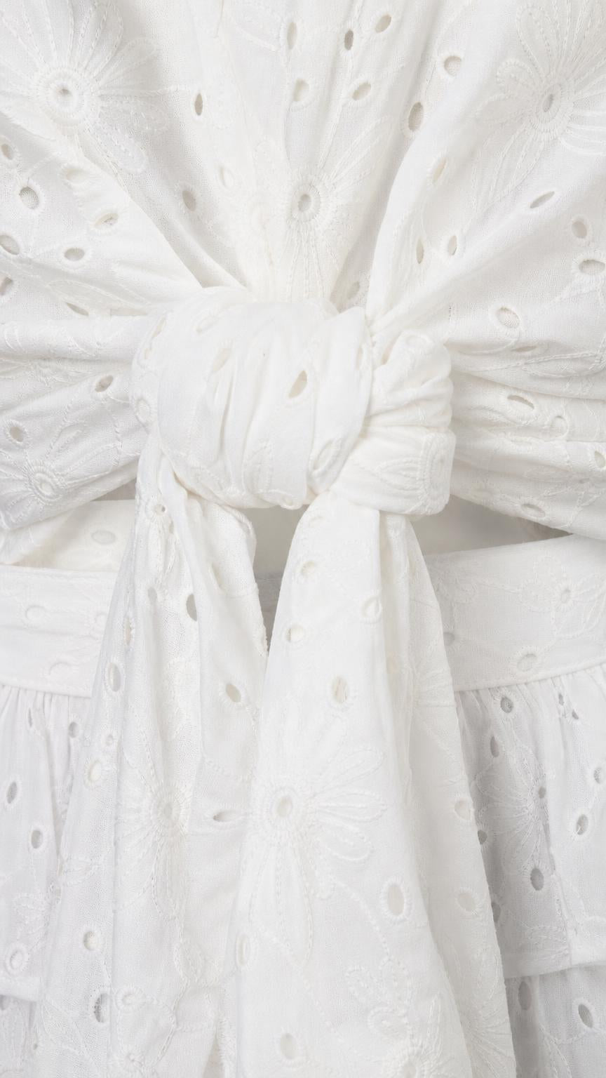 Close-up detail of the front tie closure on white eyelet crop top