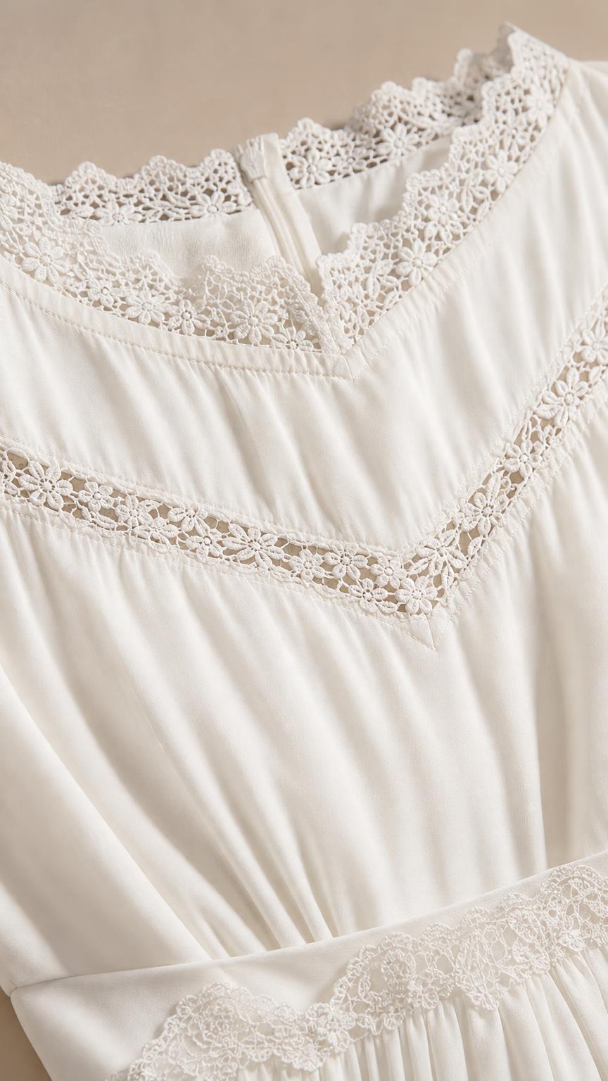 Close-up view of intricate crochet lace trim and fabric texture on white dress