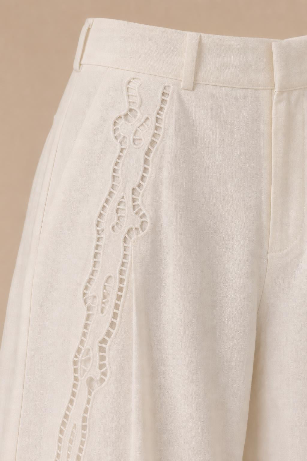 Close-up detail of side embroidery on white trousers