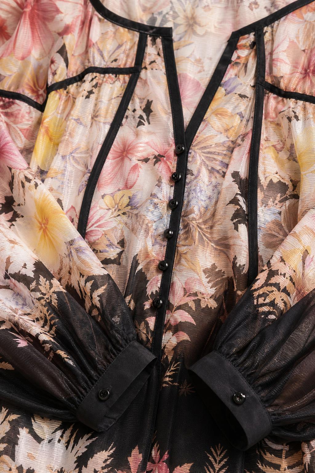 Close-up detail of V-neckline, buttons, and contrast piping