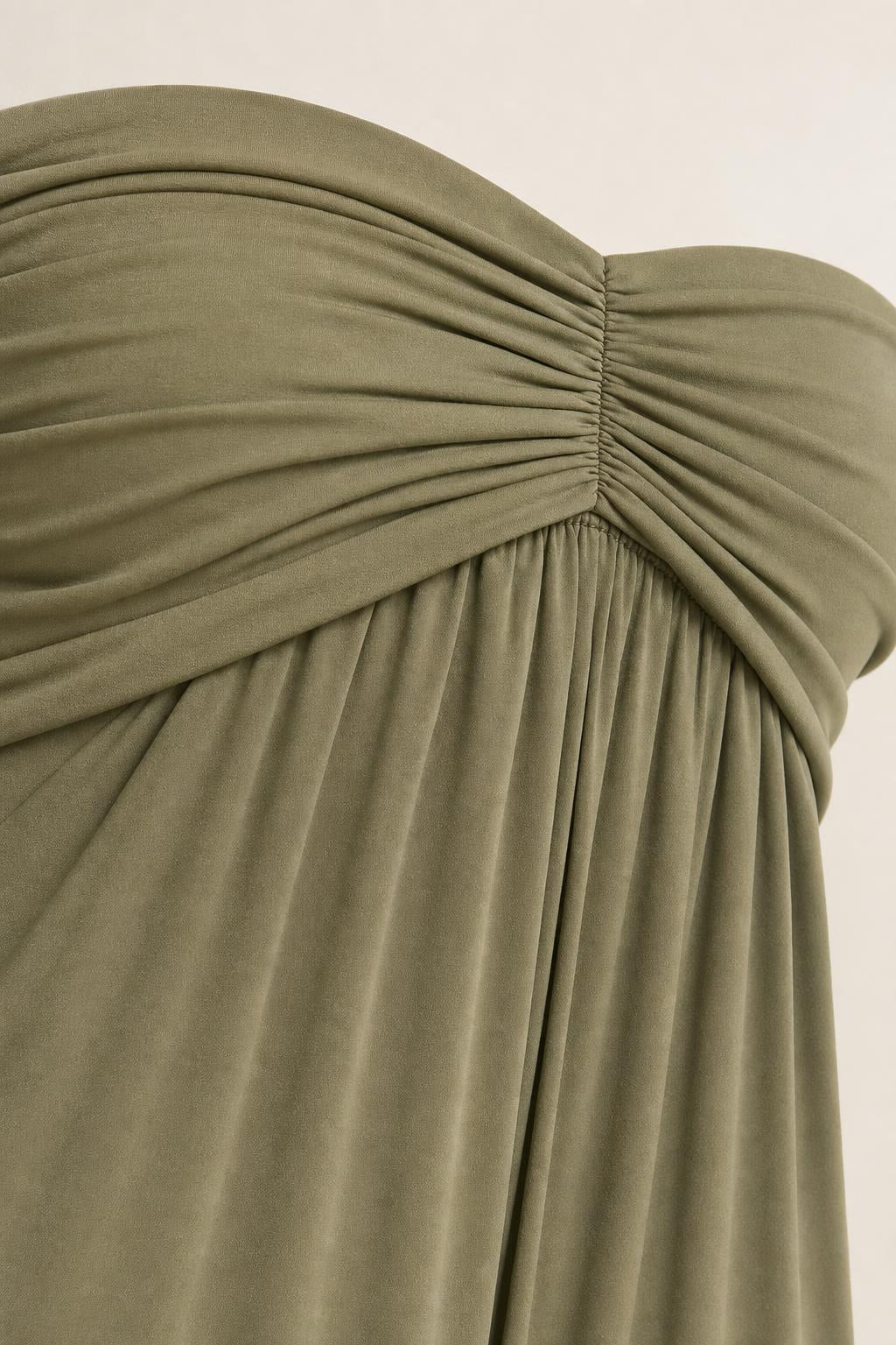 Close-up of ruched detail on olive green strapless dress bodice