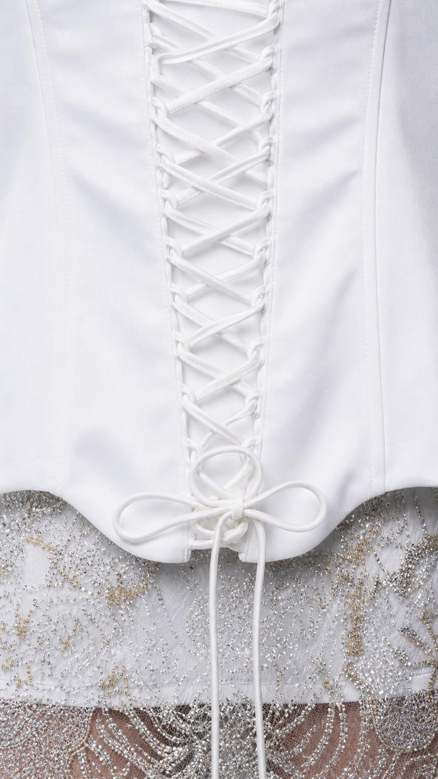 Close-up detail of white lace-up corset back and lace skirt hem