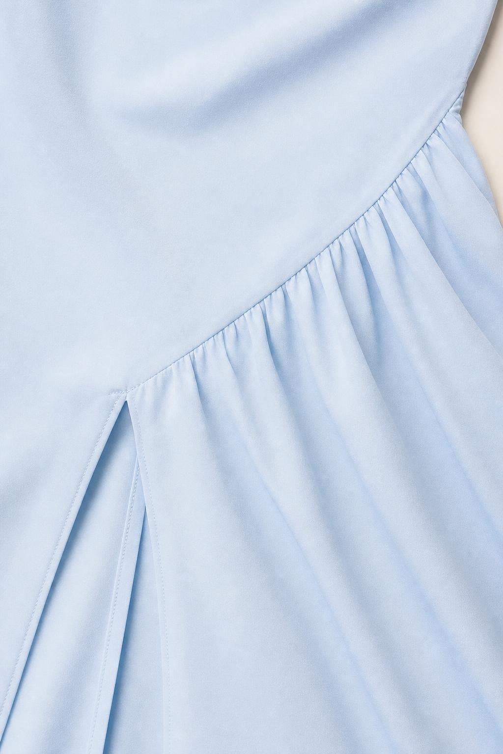 Close up of asymmetric gathered waist and slit detail