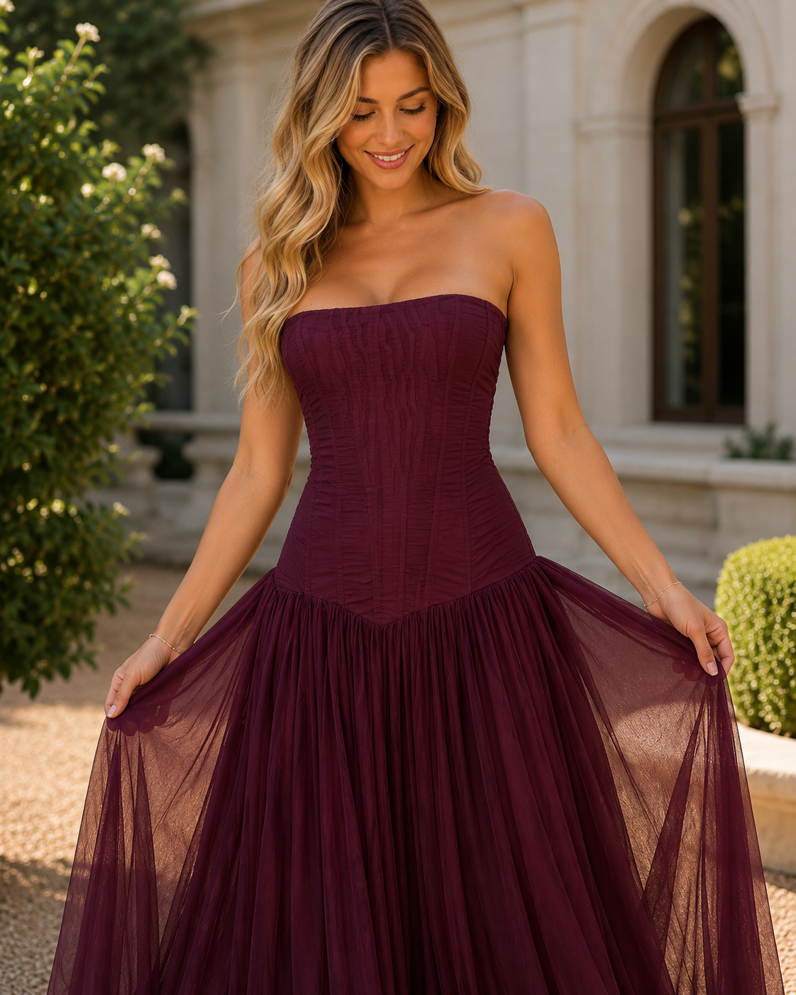 Close front view of burgundy strapless gown showing fitted bodice and sheer skirt
