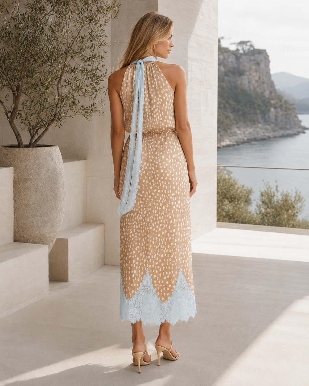 Back view of beige printed halter midi dress with long neck tie and contrast hem