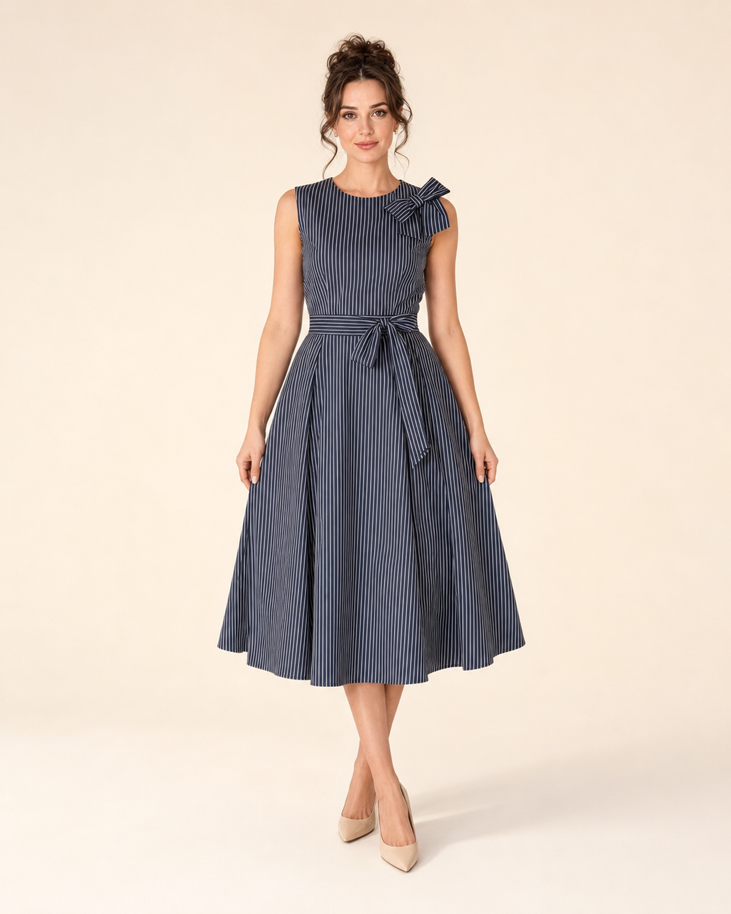 Front view of navy sleeveless striped midi dress with bow shoulder and pockets