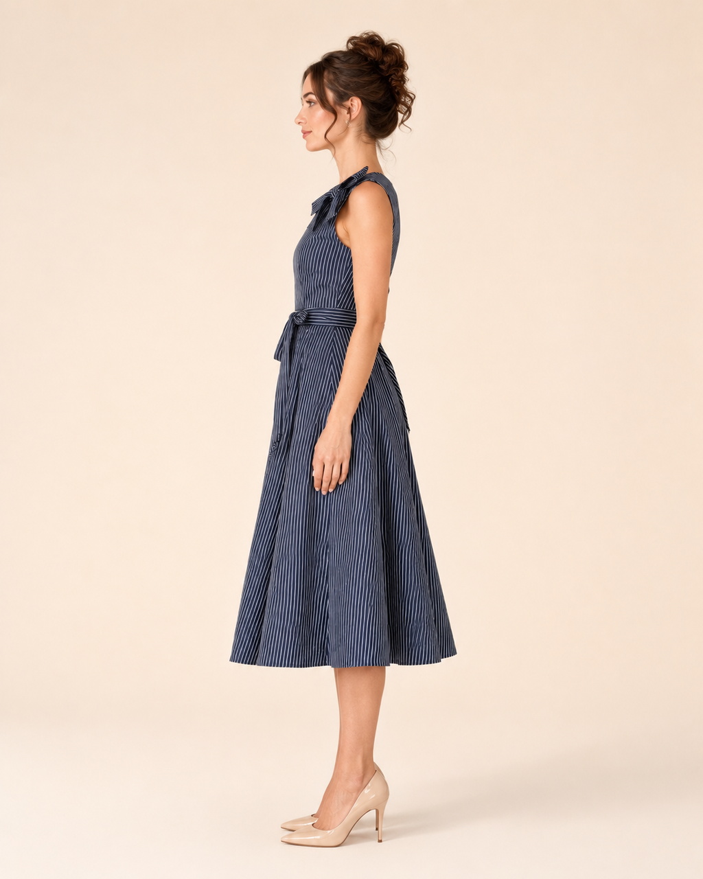 Side view of navy sleeveless striped midi dress showing shoulder bow and flared shape
